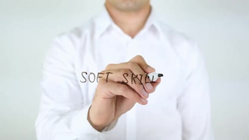 Man Writes 'Soft Skills' on Glass Surface