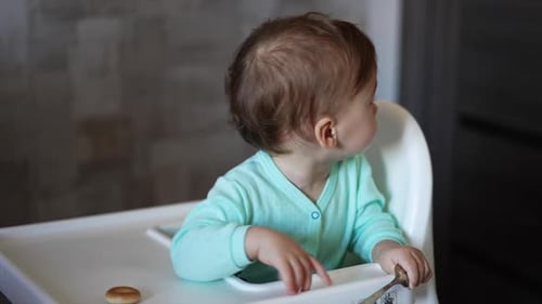 Cute Baby Sitting in High Chair Eating