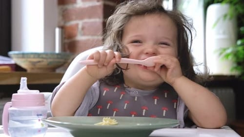 Happy Child Eating Pasta with a Fork