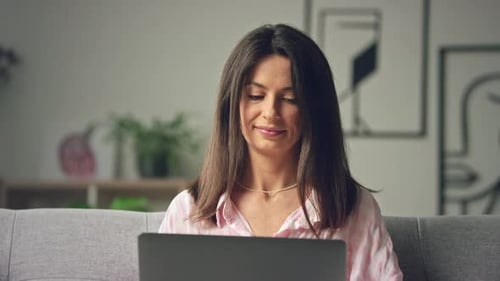 Woman Working on Laptop at Home on Couch