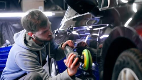 the Car Mechanic at a Service Station Doing the Final Polishing to Shine