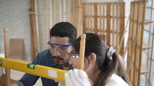 Craftspeople Constructing Wooden Furniture Piece in Workshop
