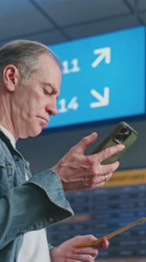 Crowded Airport Terminal Mature Man Scanning Plane Ticket Using Phone to Check Flight Information