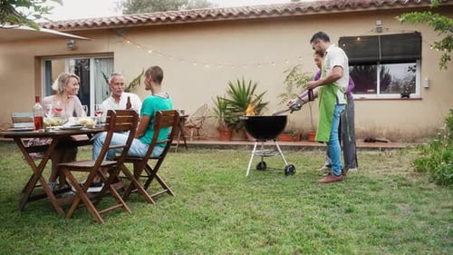 Adult Friends Having Barbecue Gathering in Home Garden Having Fun Talking and Laughing