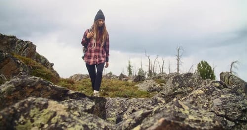 Young Woman Hiker Walking on Rocks in a Mountain Landscape
