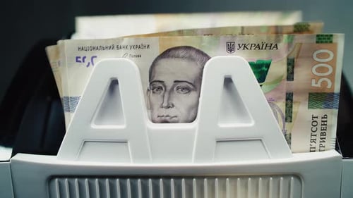 Anonymous Man Puts Money in Cash Counting Machine in Five Hundred Hryvnia Notes