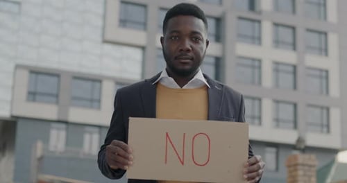 Porträt eines enttäuschten Afroamerikaners, der den Kopf schüttelt und kein Schild hält, der draußen in der Stadt steht