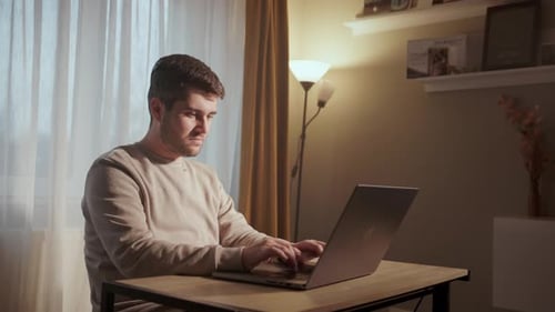 Man Working On A Laptop Computer At Home - Close Up