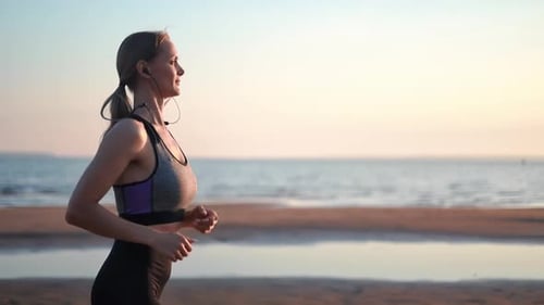 Athletic Woman Running Jogging at Sunset Morning Beach Listening Music Healthy Lifestyle Slowmo