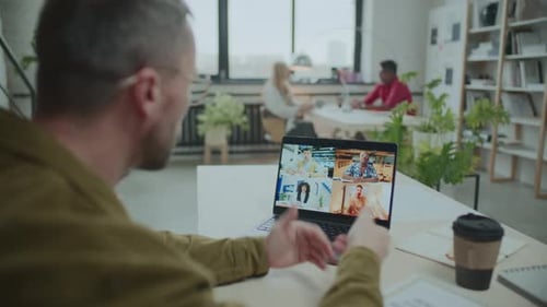 Businessman Video Conferencing with Colleagues at Workplace in Office