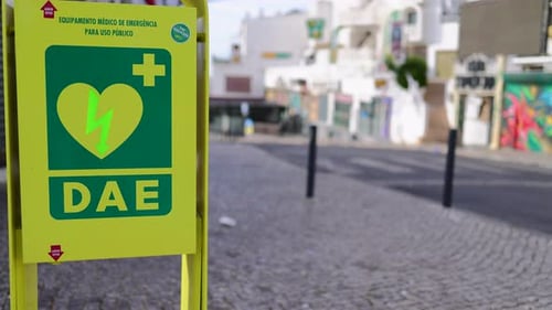An heart defibrillator machine on the public street showing the unit on the street with cars passing