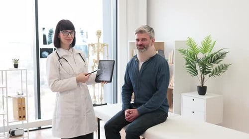 Therapist with Tablet Posing in Doctor's Office with Patient
