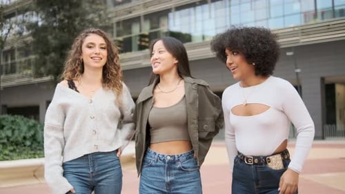Multiracial Friends Walking While Talking Together in the City Street