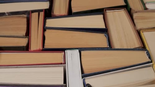 Gestapelte Hardcover-Bücher mit sichtbaren Papierkanten von oben betrachtet