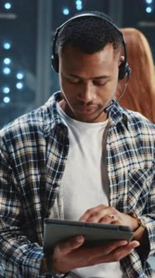 Footage of Attractive Serious Young Afroamerican Man Holding Electronic Tablet in Hands Using Gadget