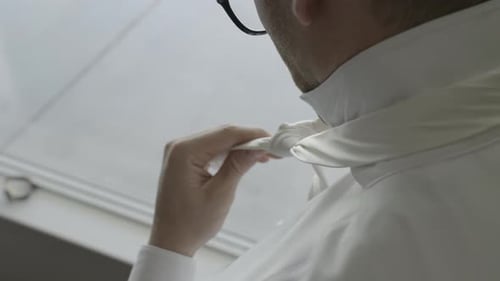 Groom tying his tie. Groom getting ready on his wedding day. Shot in 4K 60FPS for high quality slow