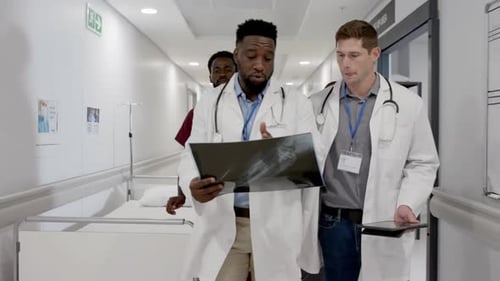 Doctors Reviewing X-Ray in Hospital Corridor