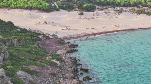 Drone view of Bolonia sand dunes in Cádiz, Spain, showing golden sandy beach, rocky coastline, and
