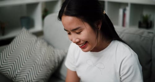 Young Woman Smiling Indoors on Couch