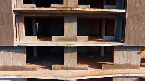 Entlang der Außenseite der im Bau befindlichen mehrstöckigen Gebäude geht es hinunter.