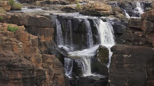 Rugged red sandstone canyon waterfall, natural geologic rock erosion