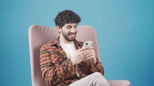 Young Man Using Mobile Phone While Relaxing
