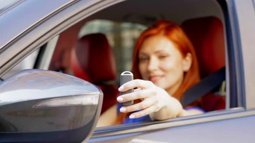 Closeup of Key of New Car in Mature Female Drivers Hand