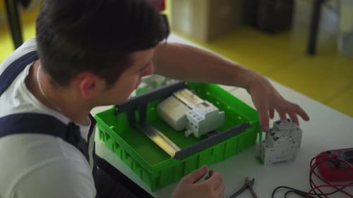 Electrician Assembles Electrical Panel Fuse Box in Workshop Worker Installs Energy Meter Switches