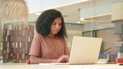 Busy Young African American Business Woman Using Laptop Working in Office