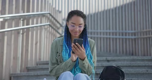 Woman Using Smartphone on Urban Steps