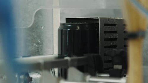Black cans on automated industrial conveyor belt