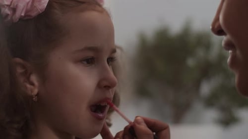 Charming Girl Receives Lipstick Application Close Up
