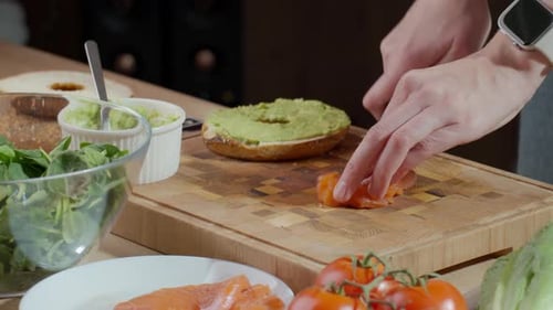 Woman Preparing Salmon and Avocado Bagel Sandwich