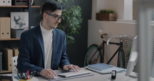 Middle Eastern Man Company Manager Working with Computer Typing Focused on Online Activity in Office