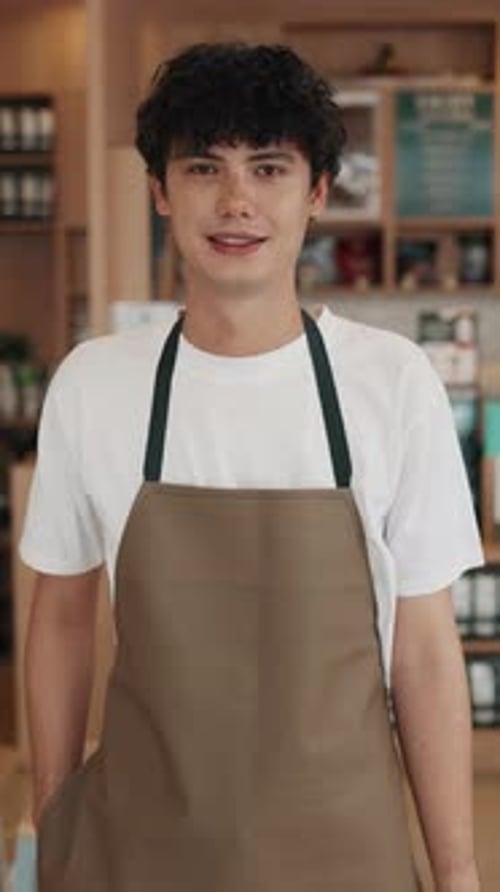 Portrait of Waiter Man in Apron Expressing Positive Emotions in Coffeeshop