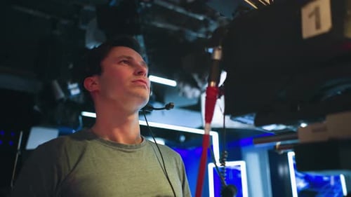 Cameraman Wearing Headset Operating Camera in Live Broadcast Studio Session