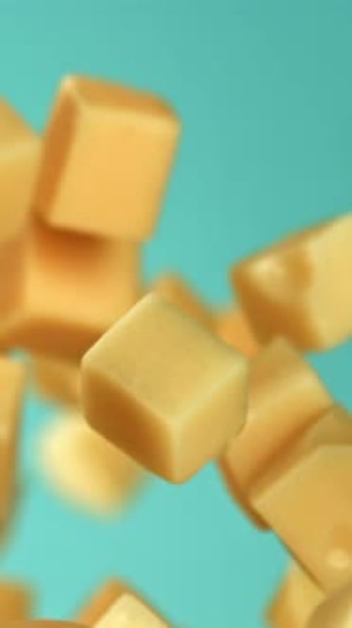 Pieces of Maasdam Cheese Fly Upwards on a Blue Background Filmed on a Highspeed Camera at 1000 Fps
