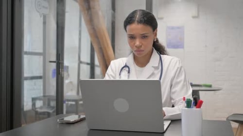 Female African Doctor Typing on Laptop
