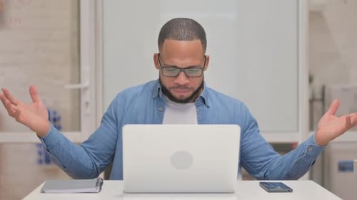 Man Frustrated with Laptop in Modern Office