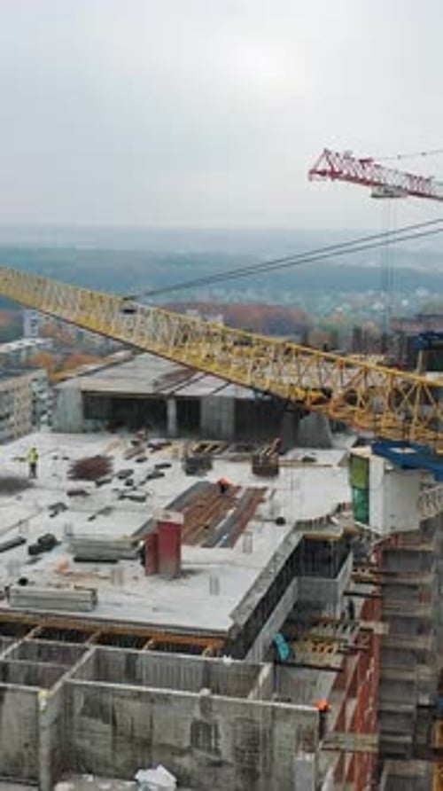 Blick von oben auf die Baustelle mit Kran. Großer Baukran auf einem Gebäudehintergrund