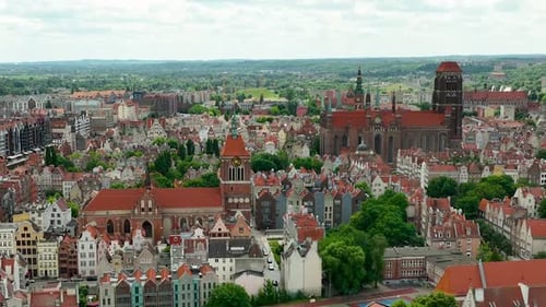 Aerial view of Gdańsk's old town, showcasing historic buildings with red-tiled roofs, churches, and