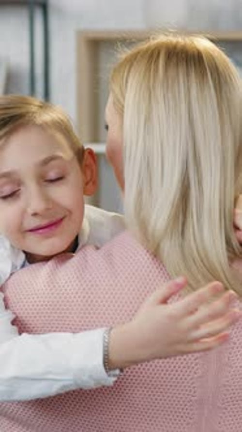Adorable, cariñosa, tierna y alegre mamá abrazando a su agradable y positivo hijo y a su hija bastante alegre