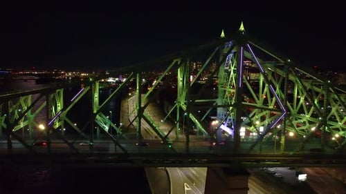 The illuminated Jacques Cartier Bridge in Montréal glows green against the night city skyline