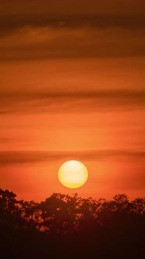 Timelapse of dramatic sunset with orange sky in a sunny day.