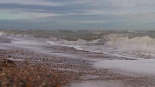 Slow Motion of Sea Waves Washing Northern Sandy Beach with Water and Foam Camera Moves Along Stormy