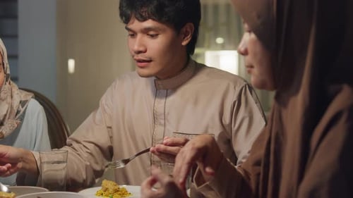 Close-up Happy Asia muslim wife talk to husband Ramadan dinner together at home.