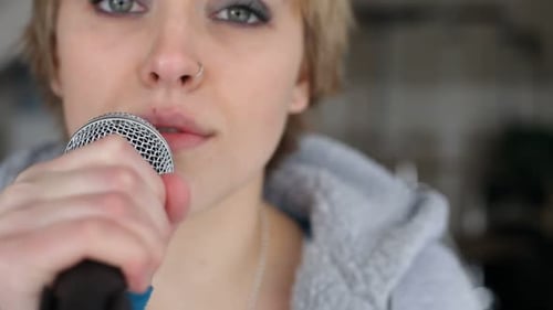 Garage band singer performing pop rock music with bandmates inside rehearsal space