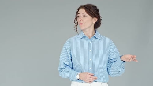 Managerin einer jungen Geschäftsfrau hält Präsentation stehend an der grauen Wand