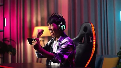 Young Adult Celebrates Victory in Mobile Game