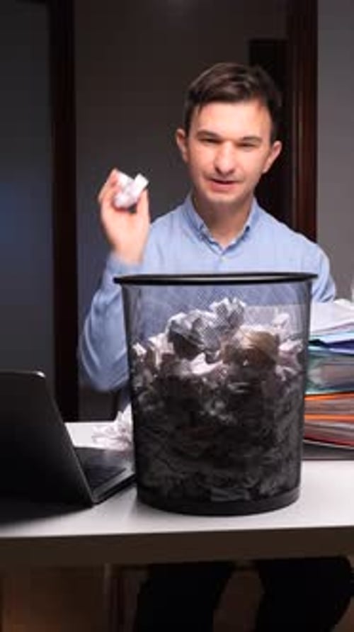 Frustrated Man Throwing Crumpled Paper Into Trash Can